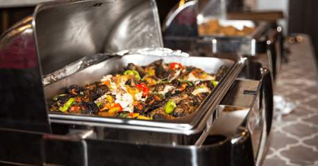 A variety of Jamaican dishes in chafing warmers, ready for buffet-style catering