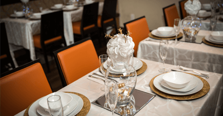 Elegant dinner party setup with professionally decorated tables and fine dining service