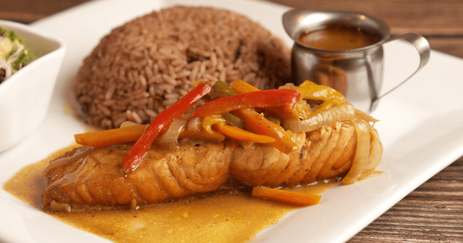 Delicious brown stew salmon alongside Caribbean-style rice and peas