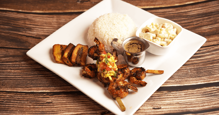 Spicy jerk shrimp paired with fluffy white rice, plantain, and macaroni salad