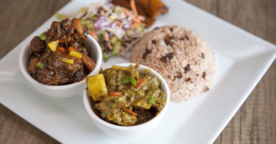Hearty Jamaican oxtail and curry goat plate with traditional sides