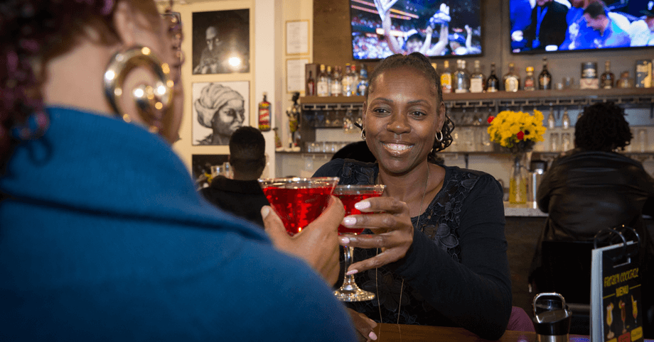 Casual night out – two women enjoying cocktails while fans watch sports