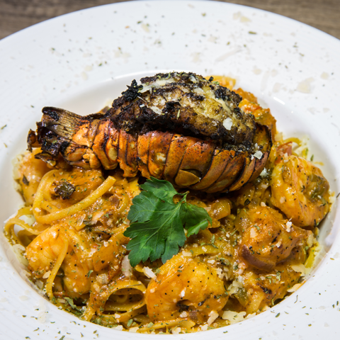 Seafood pasta topped with jerked lobster tail in creamy rose sauce – thumbnail view