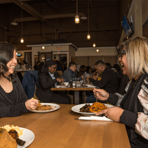 Female friends enjoying a meal together in a lively restaurant – thumbnail view